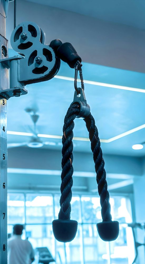 Close-up of gym equipment with rope pulley, fitness background in modern gym.